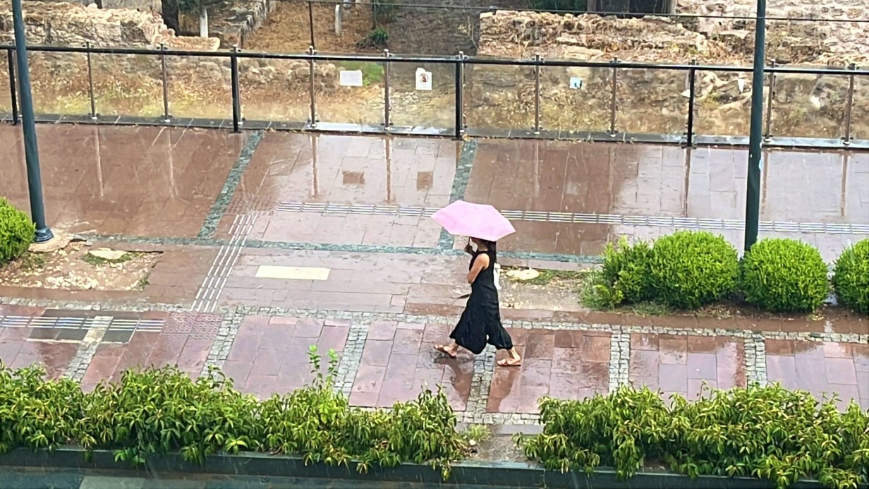 Antalya’da aniden bastıran yağmur, tatilcilere temmuz ayında şemsiye açtırdı